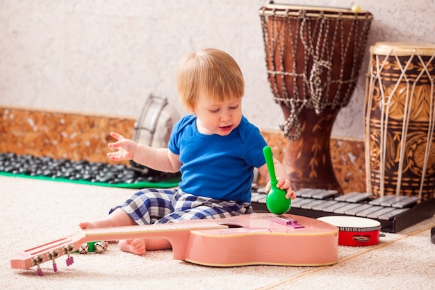 Petit garçon jouant avec enthousiasme avec divers instruments de musique