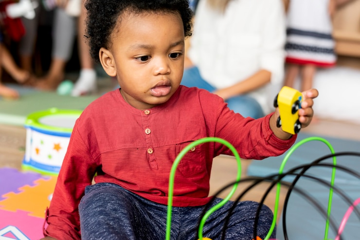 Photo petit garçon jouant des jouets dans la salle de jeux