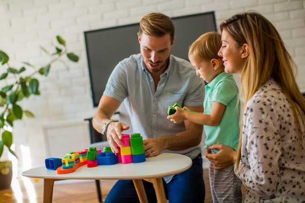 Petit garçon jouant des jouets avec mère et père à la maison