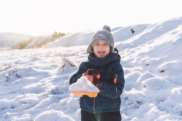 Petit garçon jouant avec de la neige