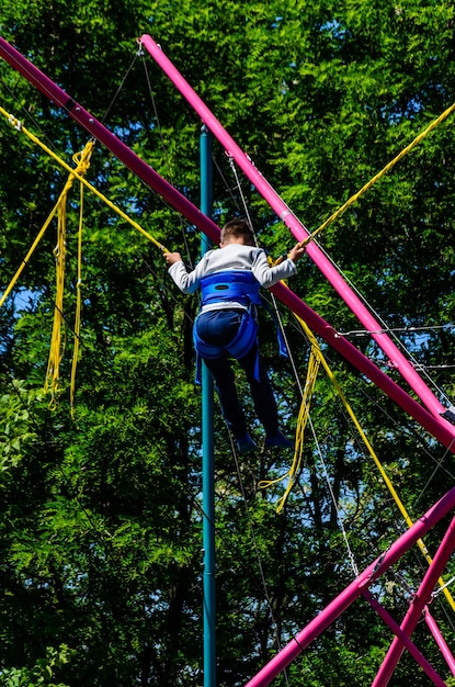 Petit garçon jouant sur un trampoline élastique