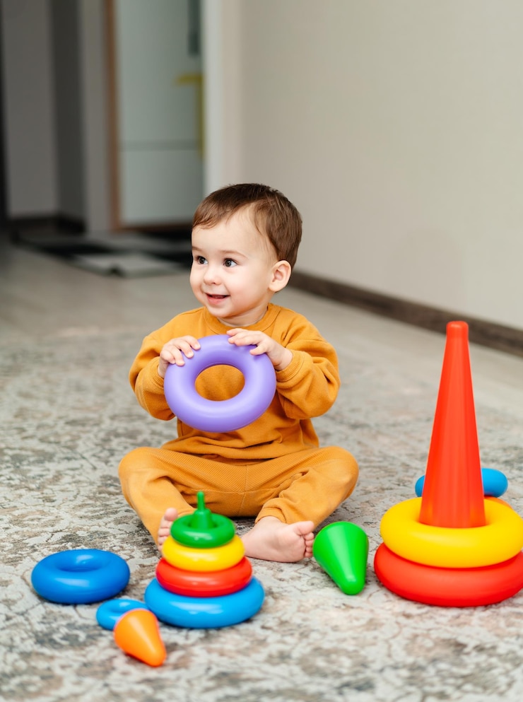 Photo le petit garçon joue avec des jouets à l'intérieur à la maison.