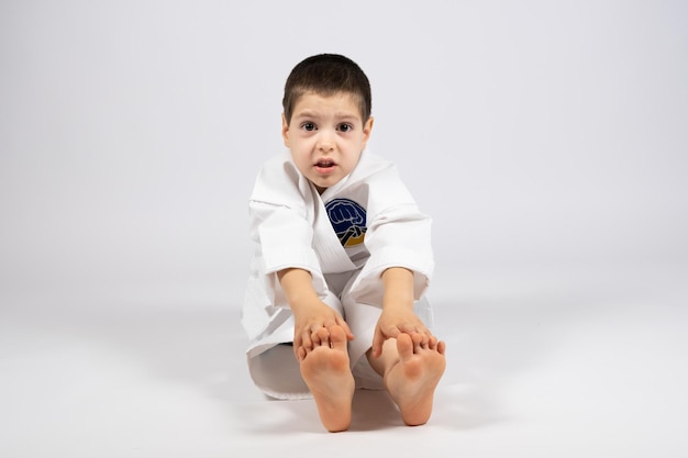 Un petit garçon en kimono faisant du karaté