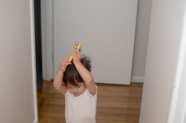 Photo petit garçon lève les cloches, instrument de musique sur la tête