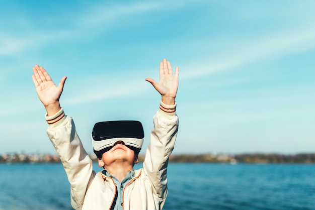 Petit garçon à lunettes de réalité virtuelle dans le parc