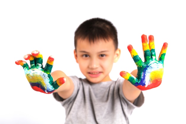 Petit garçon avec des mains peintes en peinture colorée