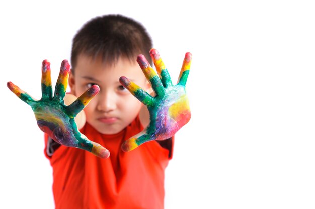 Petit garçon avec des mains peintes en peinture colorée