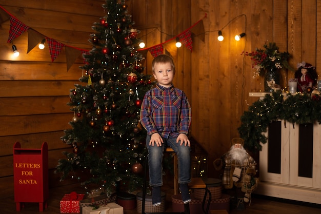 Petit garçon à la maison près de l'arbre de Noël.