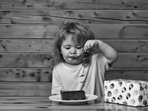 Le petit garçon mange le gâteau de fruit