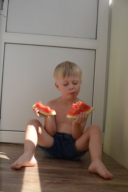 petit garçon mangeant une pastèque juteuse