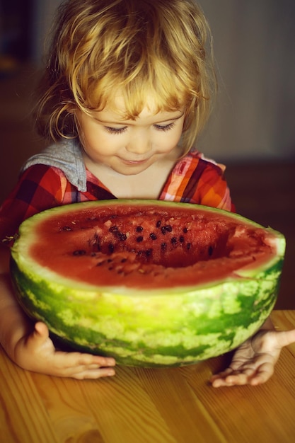 Petit garçon mangeant la pastèque rouge