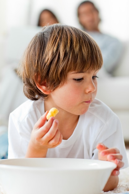 Petit garçon, manger, chips, mensonge, plancher