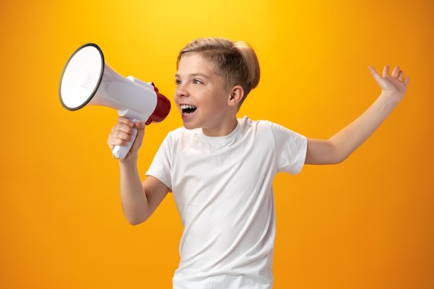 Petit garçon avec mégaphone sur fond jaune