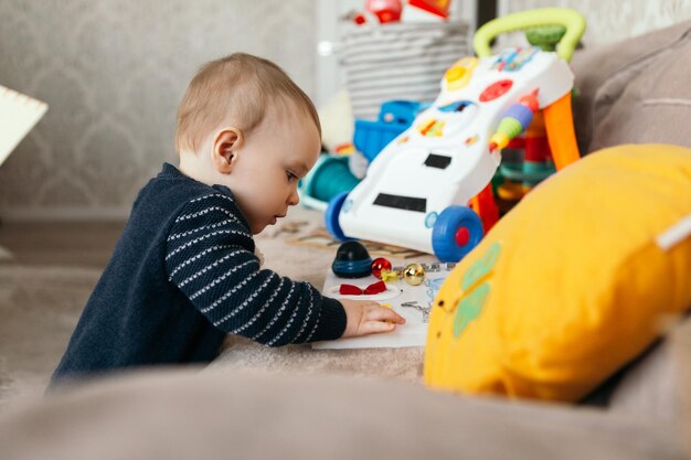 Photo petit garçon mignon enfant ludique tout-petit jouant différents tas de jouets colorés boules décorées