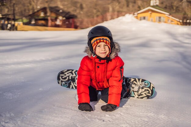 Petit garçon mignon faisant du snowboard Activités pour enfants en hiver Sports d'hiver pour enfants