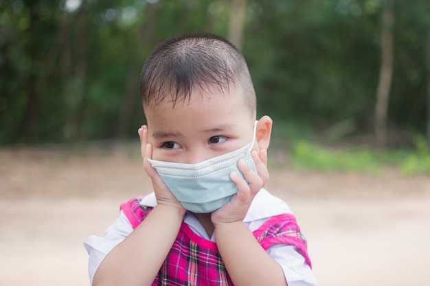 Un petit garçon mignon porte un masque pour la protection contre le coronavirus ou le covid 19.