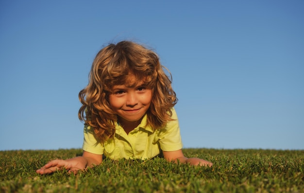 Petit garçon mignon s'étendant sur les enfants d'herbe explorant l'été de nature