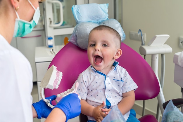 Petit garçon montrant ses dents à un médecin