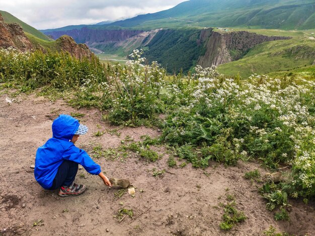 Un petit garçon nourrit des gophers dans la gorge de JilySu KabardinoBalkaria Russie juin 2021