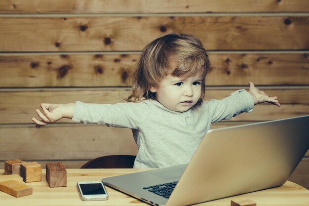 Petit garçon avec ordinateur et téléphone