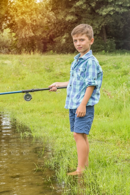 Petit garçon pêche sur la rivière
