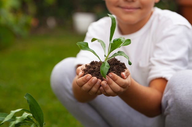 Petit garçon plantant une fleur au sol