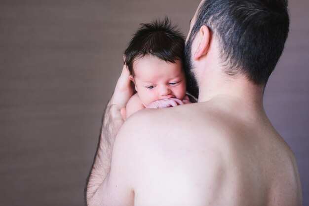 Petit garçon pleure sur l'épaule de son père