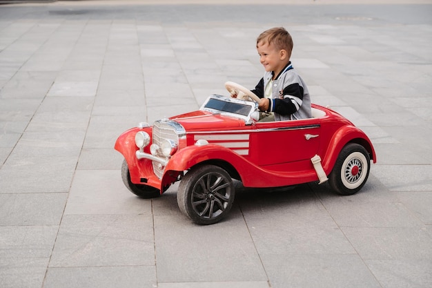 Photo un petit garçon pose dans une mini voiture de course jouez et détendez-vous à l'air frais