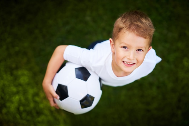 Petit garçon pratiquant le football à l'extérieur