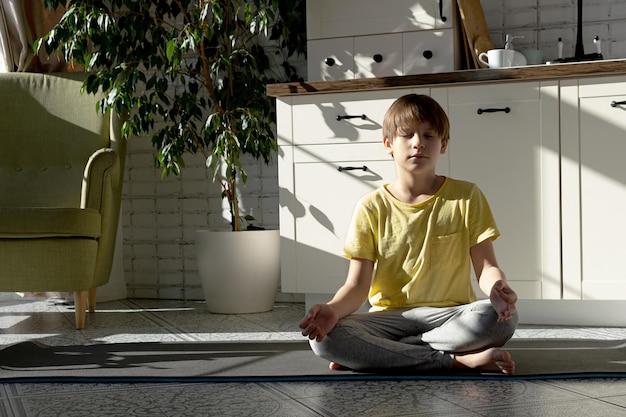 Petit garçon pratiquant le yoga étirement fitness à la maison Formation en ligne à distance aérobie à la maison Mode de vie sain coronavirus rester à la maison Enfants sport quarantaine à domicile