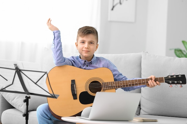 Petit garçon prenant des cours de musique en ligne à la maison