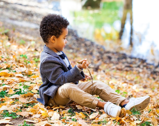 Photo un petit garçon de quatre ans posant dans un parc d'automne.