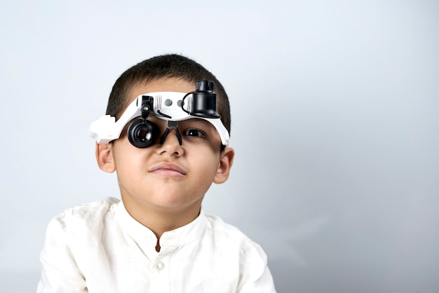 Petit garçon regardant à travers des lunettes grossissantes