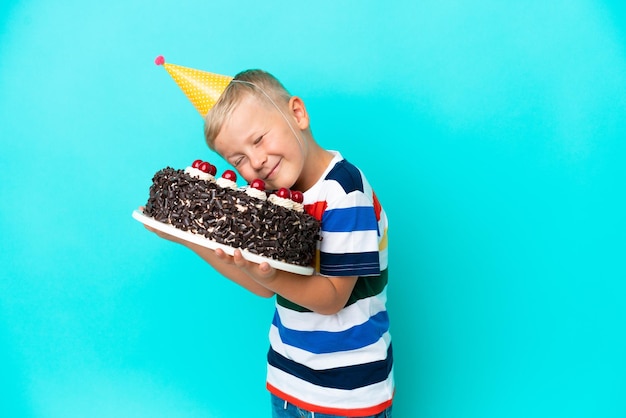 Petit garçon russe tenant un gâteau d'anniversaire sur fond isolé