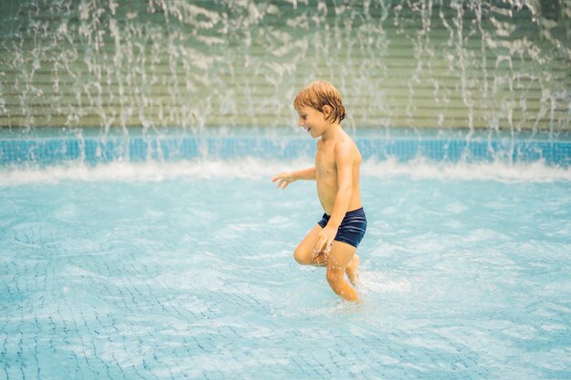 Petit garçon s'amusant à courir dans la piscine