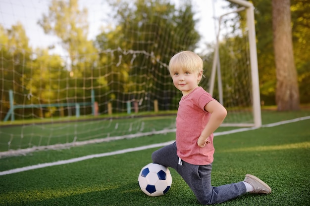 Petit garçon s&#39;amusant à jouer à un match de foot / football le jour de l&#39;été.