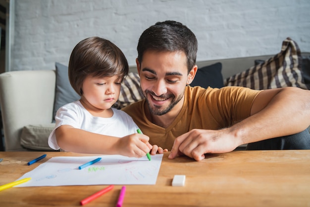 Petit garçon s'amusant avec son père à la maison.