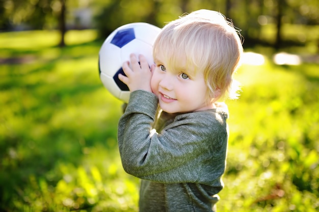 Petit garçon s&#39;amuser jouer à un match de football sur une journée d&#39;été ensoleillée