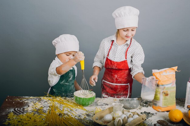 Un petit garçon avec sa soeur prépare le dîner