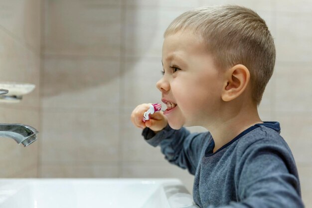 Un petit garçon se brosse les dents dans la salle de bain Hygiène et santé Gros plan