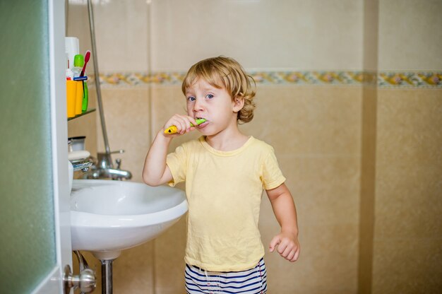 Petit garçon se brosser les dents dans la salle de bain