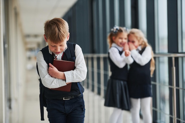 Petit garçon se fait intimider Conception du harcèlement Écoliers en uniforme ensemble dans le couloir