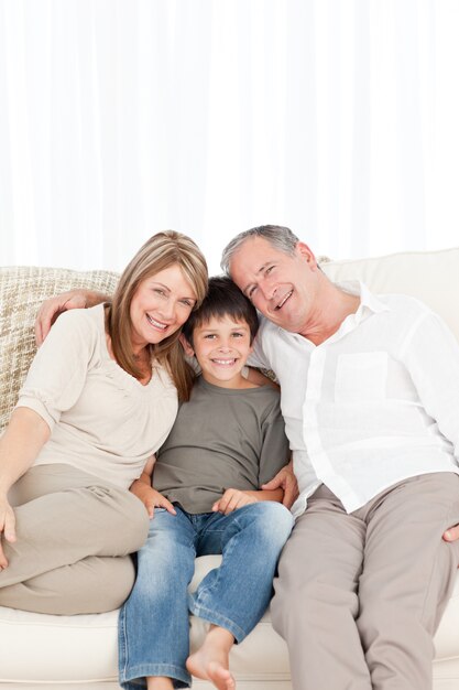 Un petit garçon avec ses grands-parents en regardant la caméra