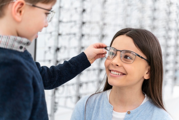 Petit garçon et soeur en magasin essayant des lunettes