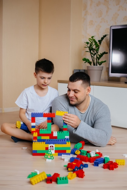 Un petit garçon avec son père est joué par un constructeur et construit une maison