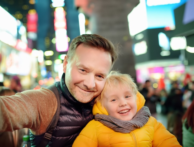 Petit Garçon Et Son Père Prenant Selfie à Times Square En Soirée