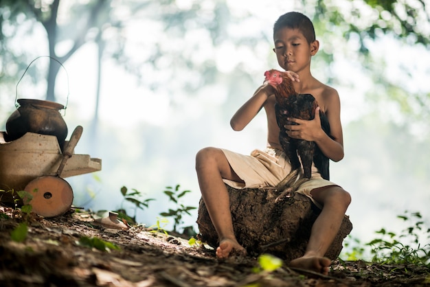 Petit Garçon Souriant Et Coq Sur La Forêt Verte Dans La Campagne