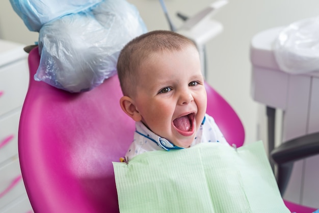 Petit garçon sourit à la chaise du dentiste