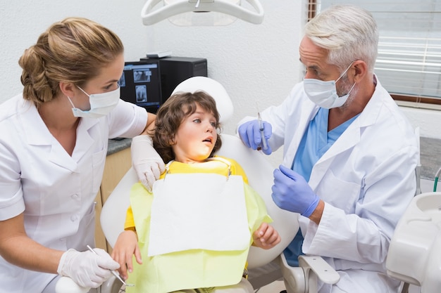 Petit garçon terrifié, regardant l&#39;aiguille dans la chaise des dentistes