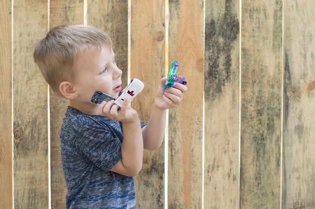 Un petit garçon tient des petites voitures